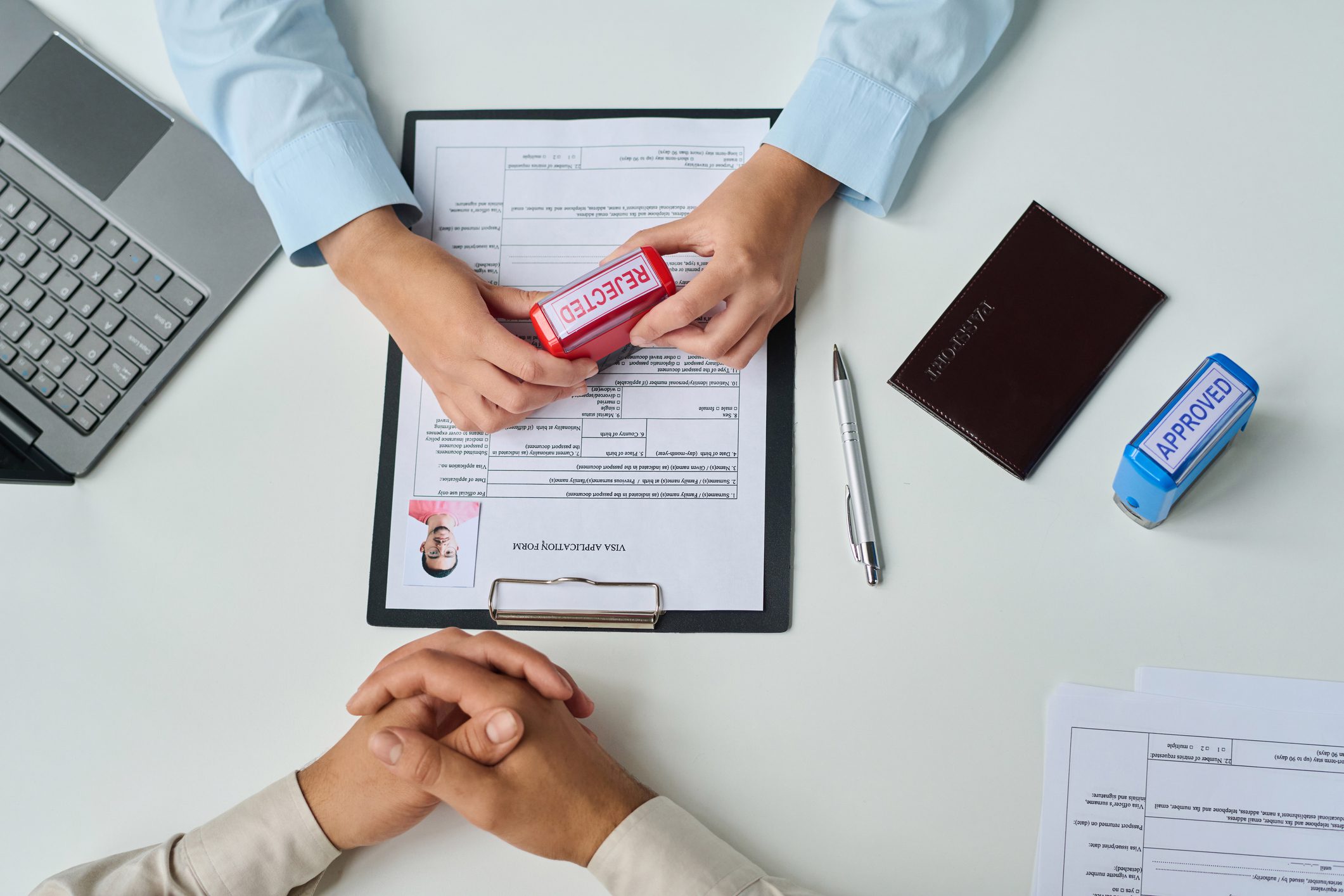 Top view of specialist of visa center declining visa for tourist putting stamp on document